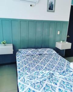 a bedroom with a bed with a blue and white quilt at Moderno y lindo apartamento de 3 habitaciones cerca al aeropuerto in Yopal