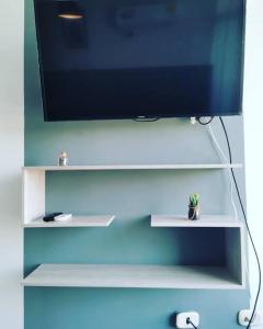 a flat screen tv sitting on a white shelf at Moderno y lindo apartamento de 3 habitaciones cerca al aeropuerto in Yopal