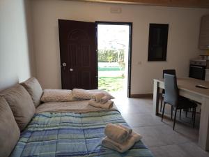 a living room with a bed and a desk and a kitchen at Agriturismo Ariston ONC 1484 in Sabaudia