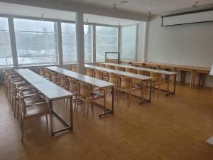 an empty classroom with tables and chairs in a room with windows at Särkkä in Äänekoski