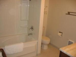 a bathroom with a toilet and a tub and a sink at Pine Tree Inn in Panaca