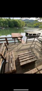 a picnic table and benches on a dock near the water at Greta’s Home 