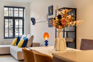 una sala de estar con una mesa con un jarrón de flores en Vrijdagmarkt by Lit d’Art, en Amberes