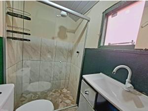 uma casa de banho com um chuveiro, um WC e um lavatório. em Seriema Hospedagem - Vila de São Jorge em São Jorge