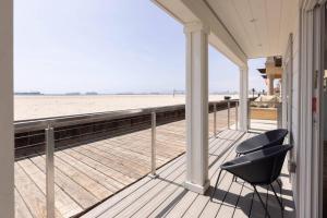 a porch with two chairs and a view of the beach at 5609 East Seaside Walk in Long Beach