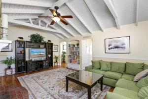 een woonkamer met een groene bank en een plafondventilator bij 821 West Bay Avenue in Newport Beach