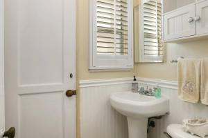 een witte badkamer met een wastafel en een spiegel bij 821 West Bay Avenue in Newport Beach +33 foto's