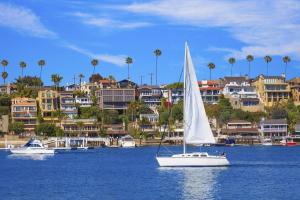 a sail boat in a body of water with buildings at 210 Forty Fourth Street in Newport Beach