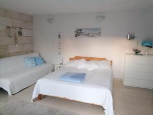um quarto branco com uma cama e um sofá em Apartmán BRAĆKI CVIJET em Sutivan