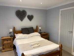 1 dormitorio con 1 cama con 2 corazones en la pared en Wicks at 26 en Sandown