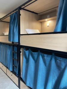 a bunk bed with blue curtains in a room at YASI Hostel in Lyon