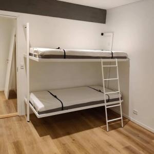 two bunk beds in a room with wooden floors at New flat with hot tub - No3 in Oyndarfjørður