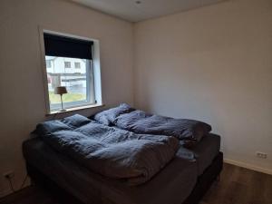 twee bedden in een kamer met een raam bij New flat with hot tub - No3 in Oyndarfjørður