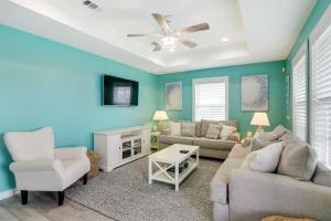 a living room with blue walls and a couch and chairs at Walk to Shore Home with Deck in Crystal Beach! in Crystal Beach