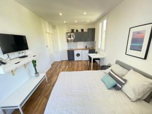 ein Wohnzimmer mit einem Bett und einem Fernseher in der Unterkunft Nice Renting - CAMBRAI02 - Studio Beach Sea View - AC - Promenade des Anglais in Nizza + 6 Fotos