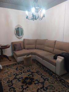 a living room with a couch and a chandelier at Casas Zé Pinto in Hospital