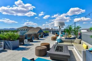 a patio with couches and chairs on a roof at Chic Apt w Jacuzzi, Pool, BBQ, & Mountain Views in Sparks
