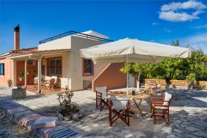 eine Terrasse mit einem Tisch und einem Sonnenschirm in der Unterkunft Casa Regina in Lithakia