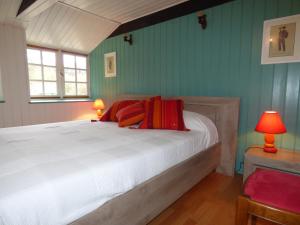 a bedroom with a bed with red pillows on it at Domaine de Pratulo in Cléden-Poher