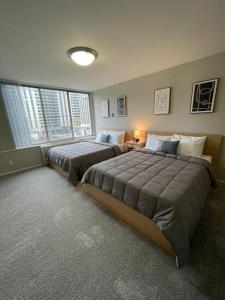 two beds in a large bedroom with two windows at Discover an exclusive Condo at Crystal City with gym in Arlington