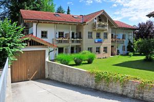 ein Haus mit einer Garage und einem Zaun in der Unterkunft Ferienwohnungen Wendelstein in Bad Feilnbach