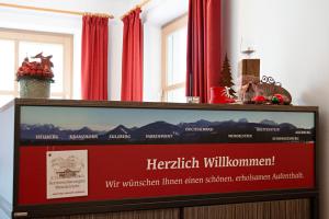 ein Podium mit einem Display in einem Zimmer mit roten Vorhängen in der Unterkunft Ferienwohnungen Wendelstein in Bad Feilnbach