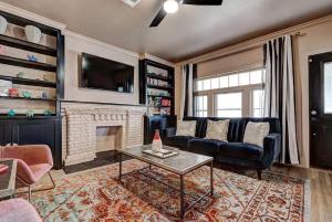a living room with a couch and a fireplace at Boho Glam Bungalow mins away Western Ave Districts in Oklahoma City