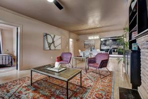 a living room with a table and purple chairs at Boho Glam Bungalow mins away Western Ave Districts in Oklahoma City