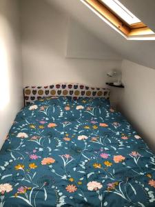 łóżko z niebieską kołdrą z kwiatami w obiekcie Appartement vue sur Mer w mieście Plérin