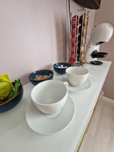 a white counter with three bowls on it at R&J Guesthouse Room in Grindavík