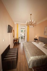 a bedroom with a large bed and a chandelier at Apartman Bianca the Best in Rijeka