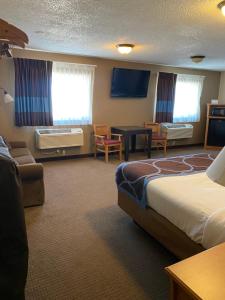 a hotel room with a bed and a living room at Super 8 by Wyndham Ogallala in Ogallala