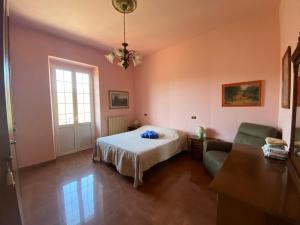 1 dormitorio con cama, sofá y ventana en Casa Vacanze Nonna Nella, en Villafranca in Lunigiana