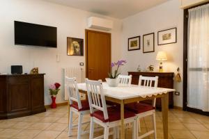 comedor con mesa blanca y sillas en Il Giardino di Boccaccio, en Castenaso