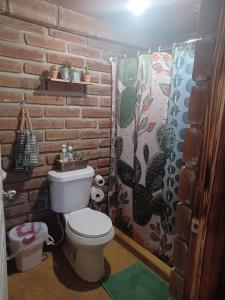 uma casa de banho com um WC e uma parede de tijolos em CABAÑA LA GRULLA em Santa Verónica