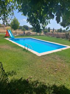 una piscina en un patio con parque infantil en Estancia Vacacional Las Nogueras, en Cuenca
