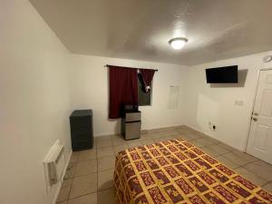1 dormitorio con 1 cama y TV en Crown Inn & Suites, en Spring Valley
