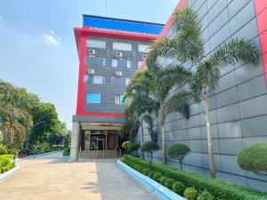 a building with a palm tree in front of it at CCULB Resort & Convention Hall in Gazipur
