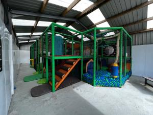 a play room with a green play structure at Jungle House no.26 at Three Lochs Holiday Park in Newton Stewart