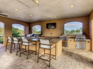 a kitchen with four bar stools and some windows at A Pleasant Stay Near Disney in Kissimmee