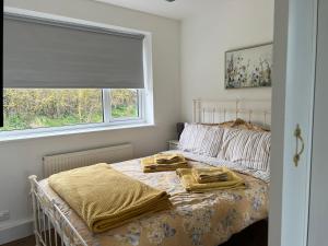 1 dormitorio con 1 cama con mantas y ventana en SEAVIEW self-catering coastal bungalow in rural West Wight en Freshwater