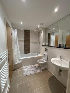 a bathroom with a sink and a toilet and a tub at Cosy apartment in West London in London