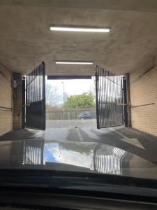 an empty parking lot with gates in a parking garage at Cosy apartment in West London in London