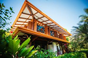 a house with a gambrel roof and windows at Blue Osa Beach Resort & Spa in Puerto Jiménez
