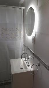 La salle de bains blanche est pourvue d'un lavabo et d'un miroir. dans l'établissement CABAÑAS MAY ., à San Rafael