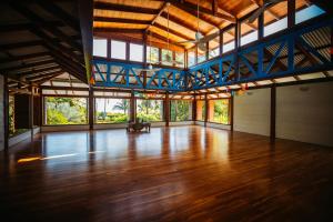 a large room with a wooden floor and large windows at Blue Osa Beach Resort & Spa in Puerto Jiménez