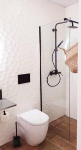 a white bathroom with a toilet and a shower at Serendipia: tu hogar en este blanco pueblo in Frigiliana