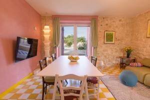 a kitchen and living room with a table and chairs at Casa Farlisa, villa esclusiva con piscina, jacuzzi, palestra, parco giochi, bbq a 5 minuti dal mare in Scicli