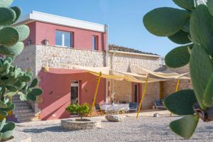 a house with a tent in front of it at Casa Farlisa, villa esclusiva con piscina, jacuzzi, palestra, parco giochi, bbq a 5 minuti dal mare in Scicli