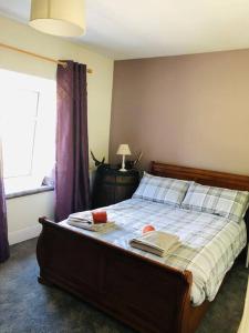 - une chambre avec un lit avec 2 livres et une fenêtre dans l'établissement Snowdon Cottage, à Dinorwic
